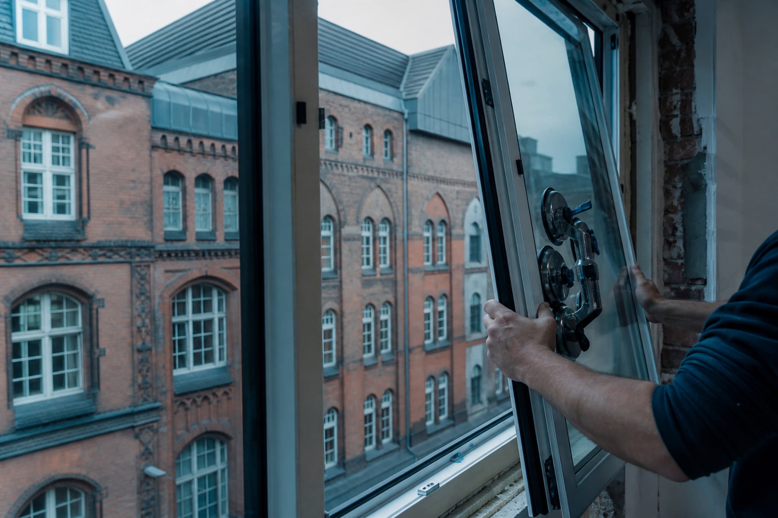 Isolierglasscheibe beim Einbau ins Fenster, mit Saugheber gehalten